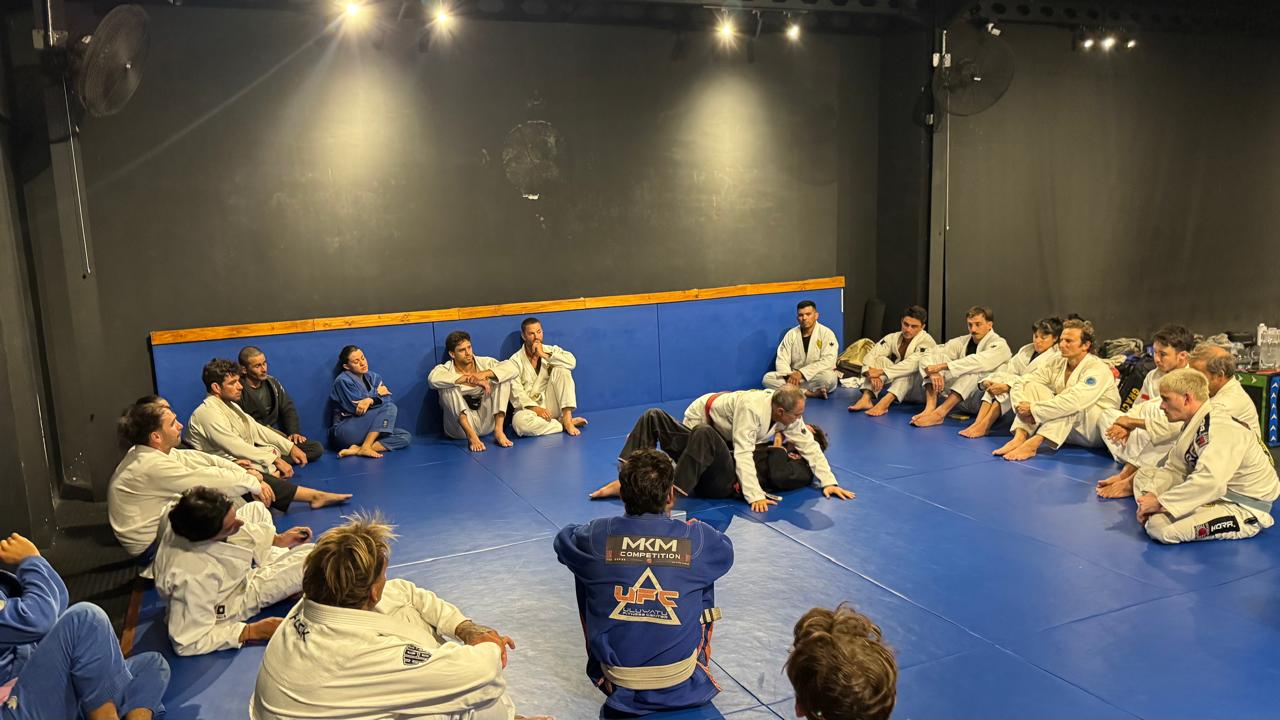 Adults training Brazilian Jiu Jitsu technique on the mats